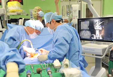 김긍년 교수가 O-ARM으로 촬영된 환자의 3D 영상을 네이게이션 영상으로 확인하며 수술하고 있는 모습.