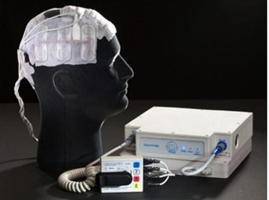 전기장 종양치료기를 머리에 착용한 모형과 주변 장치. 이 장치는 휴대할 수 있고, 일반 전원으로 충전 가능하다. 현재 미국에서는 FDA 승인 하에 교모세포종 환자의 치료에 쓰이고 있다.
