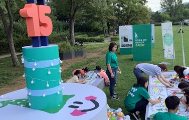 “초록산타로 따뜻해진 세상 다 함께 색칠해볼까요” 일반 시민들이 초록산타 상상학교 프로그램인 미술 게임에 참여해 단체 작품을 제작하고 있는 모습.