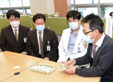 금기창 연세암병원장(왼쪽에서 세 번째)이 원무팀 직원들과 함께 기부금을 확인하고 있다.