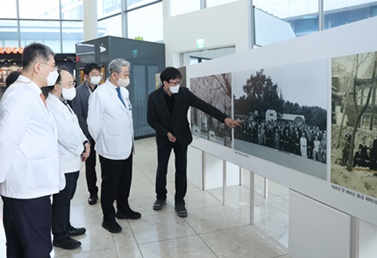 윤동섭 의료원장(오른쪽 두 번째)이 1일 에비슨 동상 사진 전시회에서 사진을 관람하고 있다.(자료 연세의료원 제공).