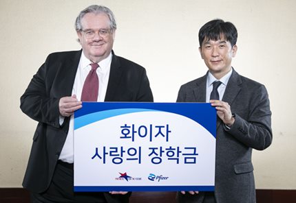 한국화이자제약 오동욱 대표이사 사장이 미래의동반자재단 제프리 존스 이사장에게 ‘화이자 사랑의 장학금’을 전달하고 있다.